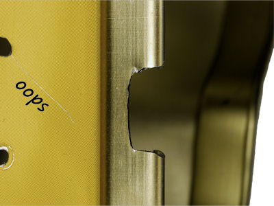 Ground notch in candy tin lip for wire hole