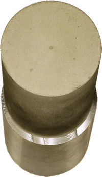 Narrower tarnished magnesium cylinder on top of newly machined correctly sized cylinder