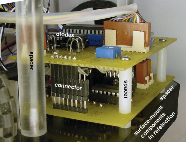 Circuit board stacks showing various spacers and a reflection of underside components.