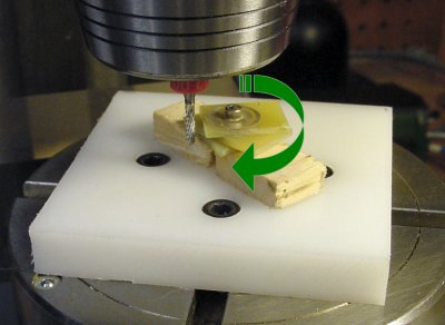 Cutting a round PCB on a milling machine using a fixture attached to a rotary table.