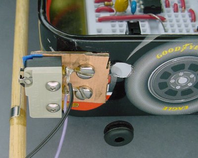 Hole in tin for rubber grommet to protect switch wires.