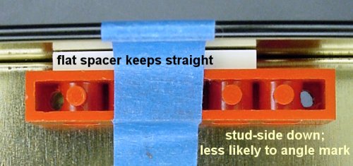 Positioning a Lego beam using a flat Lego as a spacer.