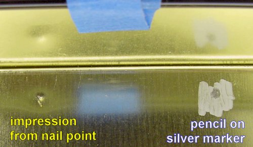 Nail dent and pencil mark.