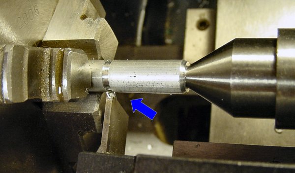 Cutting off a length of rod on a lathe using a cut-off blade and a dead center in the tailstock.