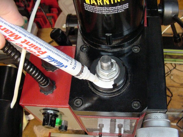 A white paint pen marks a portion of the black spindle top so that rotations can be measured optically.