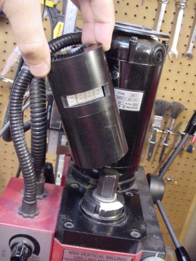 The tachometer replaces the spindle cap and snaps onto the milling machine.