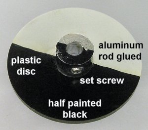 A plastic disc with a short length of aluminum rod is painted half black and half white to detect motor rotation.