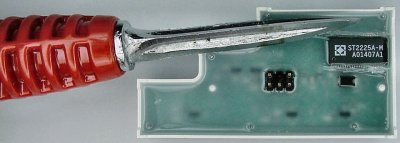 A reamer scrapes off epoxy from around an encapsulated chip.