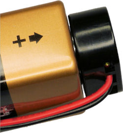 Nine volt molded plastic battery cap with shroud