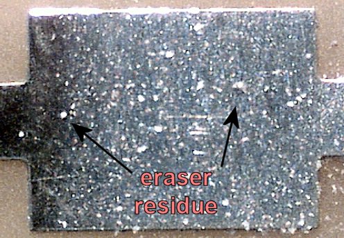 After a few quick exhales, the larger eraser residue was blown away from the pad (60x magnification).