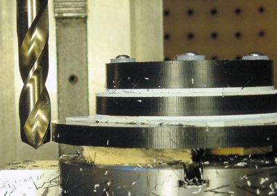 Determining the maximum drill depth by first lowering the drill outside of the workpiece.