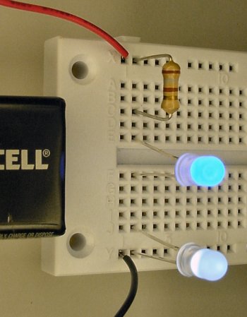A blue LED and white LED on a solderless breadboard.