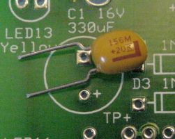 Tantalum capacitor with positive band ready to insert in '+' hole