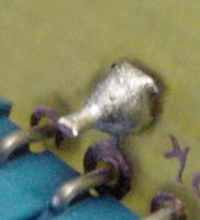 Bare wire soldered on both sides of the board to complete a via