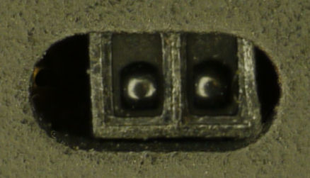 Tiny 4 mm reflective-pair edge sensor peeking through bottom plate